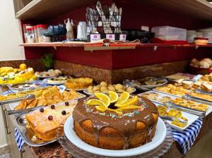 a buffet of different types of cakes and pastries at Domus Hotel Torre - Canaã dos Carajás in Canaã dos Carajás +14 photos
