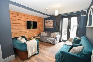 a living room with two couches and a flat screen tv at 2 Private Rooms in Shared Apartment with Kitchen in Leeds