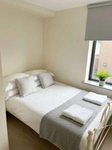 a white bed in a room with a window at 2 Private Rooms in Shared Apartment with Kitchen in Leeds