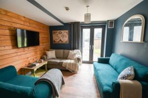 a living room with blue couches and a flat screen tv at 2 Private Rooms in Shared Apartment with Kitchen in Leeds +7 photos