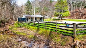 a fence in front of a small house at Brookside Cabin in South Bloomingville +25 photos