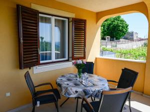 a table and chairs on a balcony with a window at Villa Kapitulac in Grižane