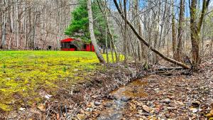 a red barn in the middle of a forest at Creekside Hideaway in Laurelville