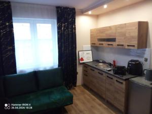 a kitchen with a couch and a sink and a window at Krakowski in Boguszów-Gorce