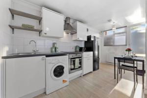 a kitchen with a washing machine and a sink at Private Annex with Gated Driveway near Grove Park Station in Hither Green