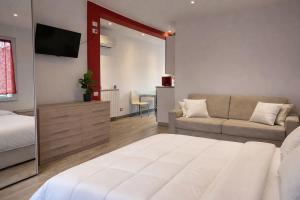 a bedroom with a bed and a couch and a tv at Arvén Crimson in Marghera