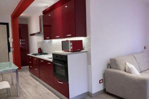 a kitchen with red cabinets and a red microwave at Arvén Crimson in Marghera