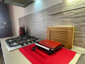 a kitchen with a stove and a red rug at Arvén Crimson in Marghera +19 photos