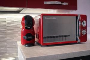 a red microwave sitting on top of a kitchen counter at Arvén Crimson in Marghera