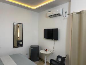 a bedroom with a bed and a tv on the wall at Guest House HEBERTOGO in Lomé