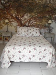 a bedroom with a bed with a tree background at Carabas84 in Carpentras