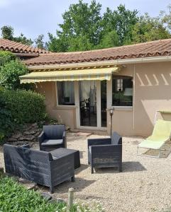 a patio with chairs and tables and a house at Carabas84 in Carpentras