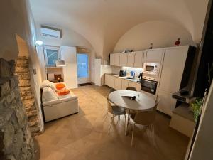 a living room with a table and a kitchen at Casa Vacanza Zhurian in Ginestra