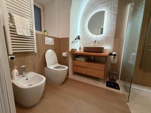 a bathroom with a toilet and a sink and a mirror at Casa Vacanza Zhurian in Ginestra +26 photos
