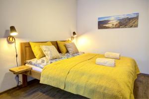 a bedroom with a bed with a yellow comforter at Apartmány Lipno-Hory in Horní Planá