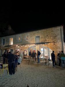 a group of people standing outside of a building at night at Sirona - domaine viticole et chambres d'hôtes in Le Puy-Notre-Dame
