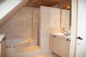 a bathroom with a tub and a sink at Vakantiehuis 1 - Ter Douve in Heuvelland +48 photos