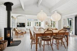 a dining room with a table and chairs and a fireplace at TV1721-Jerup-Engsigen-12 in Bratten Strand
