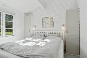 a white bedroom with a bed and a window at TV1721-Jerup-Engsigen-12 in Bratten Strand