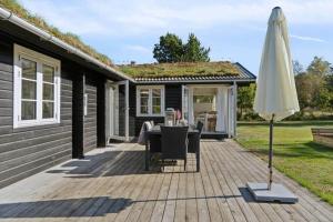 a patio with a table and an umbrella at TV1721-Jerup-Engsigen-12 in Bratten Strand