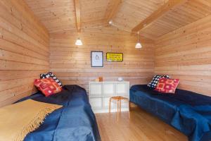 two beds in a room with wooden walls at TV1718-Bindslev-Astersvej-4 in Tversted
