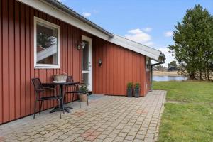 a red house with a table on a patio at TV1718-Bindslev-Astersvej-4 in Tversted