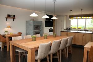 a kitchen and dining room with a wooden table and chairs at Vakantiehuis 1 - Ter Douve in Heuvelland