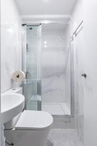a white bathroom with a shower and a toilet at LooP Alcala in Madrid +88 photos