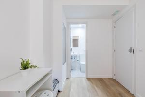 a white bathroom with a sink and a toilet at LooP Alcala in Madrid