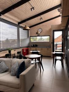 a living room with a couch and tables and windows at Herco Suites in Traiguén