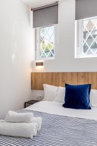 a bedroom with two beds with blue pillows at LooP Alcala in Madrid