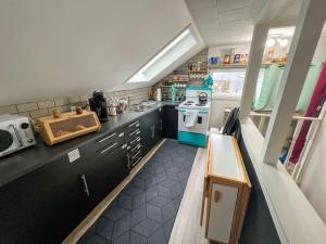 a small kitchen with black cabinets and a stove at Quaint Attic Suite with Heated Pool Year-Round in Victoria