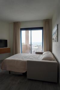 a bedroom with a large bed and a large window at Casa Aniste in Castelsardo
