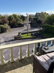 a balcony with a white railing and a view of a garden at Sea Breeze B&B in Clonakilty
