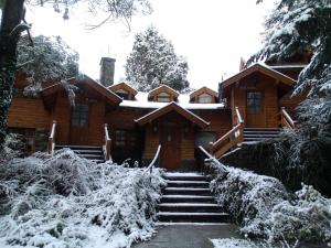 a log cabin with snow on the stairs at Cabañas Rincon del Lago in Villa La Angostura +75 photos