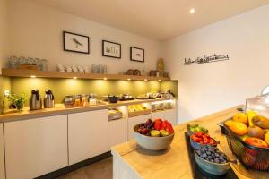 a kitchen with a bowl of fruit on a table at De Vlindertuin in Nes
