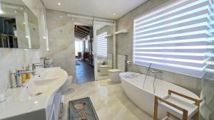 a bathroom with a tub and two sinks and a bath tub at Ashore - Beachfront Paradise in St. Helena Bay +67 photos