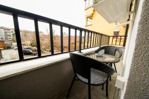 a balcony with two chairs and a table and a window at Еlite central stay apartment in Pleven