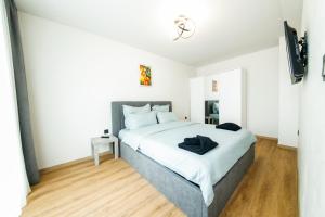 a bedroom with a bed with white walls and wooden floors at Еlite central stay apartment in Pleven