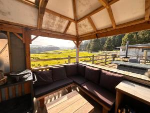 a couch in a porch with a view of a field at The Loft in Burnley