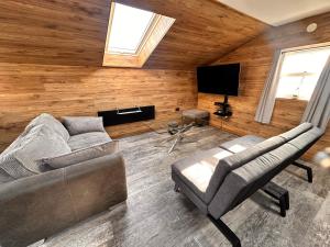 a living room with a couch and a tv at The Loft in Burnley