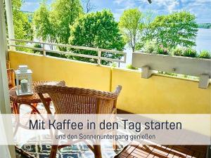 a balcony with a table and chairs and a view of the water at Heimathafen Dieksee - mit direktem Seeblick & Balkon am Dieksee in Malente