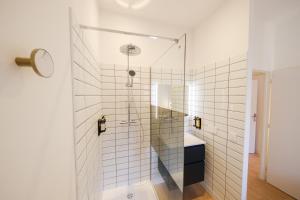 a shower with a glass door in a bathroom at Les Suites du Parc - Elégance et lumière face au Parc Simone Veil appartement 2 chambres à 2 minutes des halles in Sète +9 photos