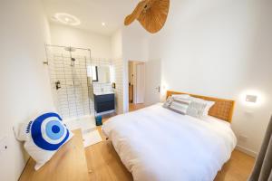 a bedroom with a large bed and a shower at Les Suites du Parc - Elégance et lumière face au Parc Simone Veil appartement 2 chambres à 2 minutes des halles in Sète