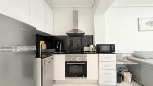 a kitchen with white cabinets and a stove top oven at Caballero in Torrevieja