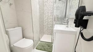 a bathroom with a toilet and a sink and a phone at Caballero in Torrevieja