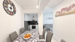 a kitchen and dining room with a table and a clock at Caballero in Torrevieja +12 photos