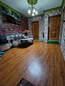 a living room with a couch and a brick wall at Minnat Home Stay in Srinagar