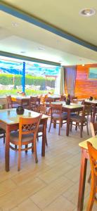 a restaurant with wooden tables and chairs andwindows at 4S Hotel Dahab in Dahab