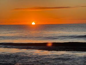 a sunset on the beach with the ocean at The Beach Loft by Xio in Humacao